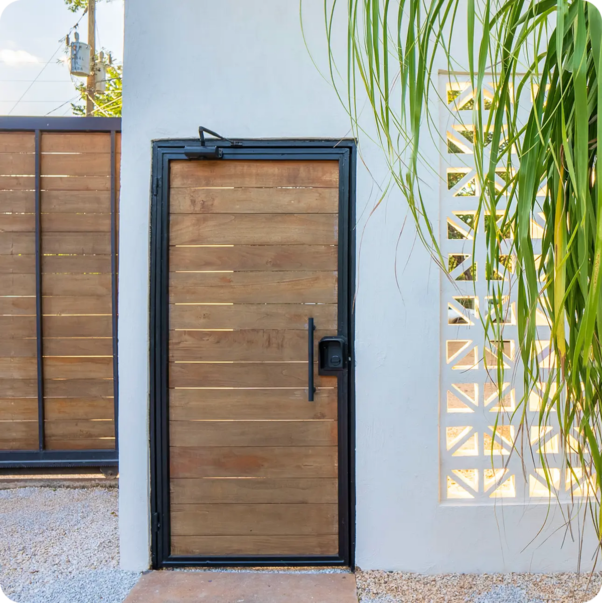 
ULTRALOQ Bolt Mission smart lock installed on a modern wooden gate
